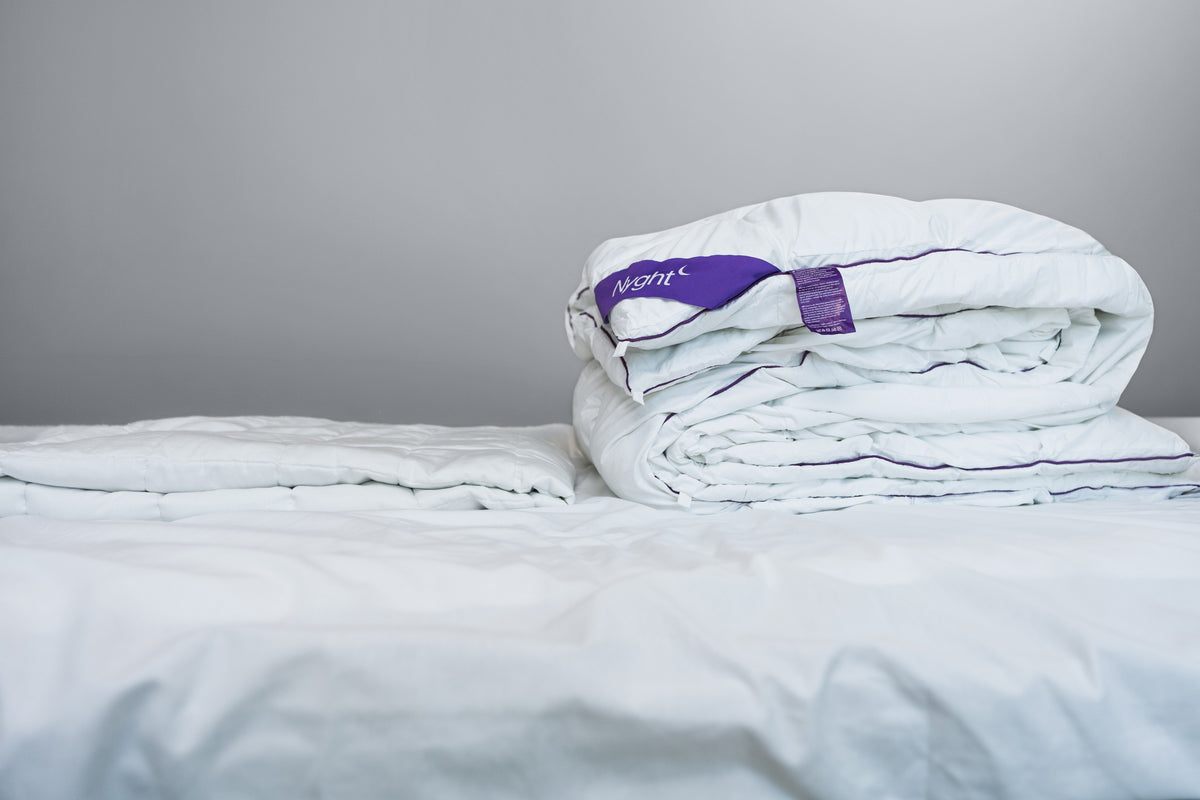 NYGHT Hybridduvet foldet på sengen